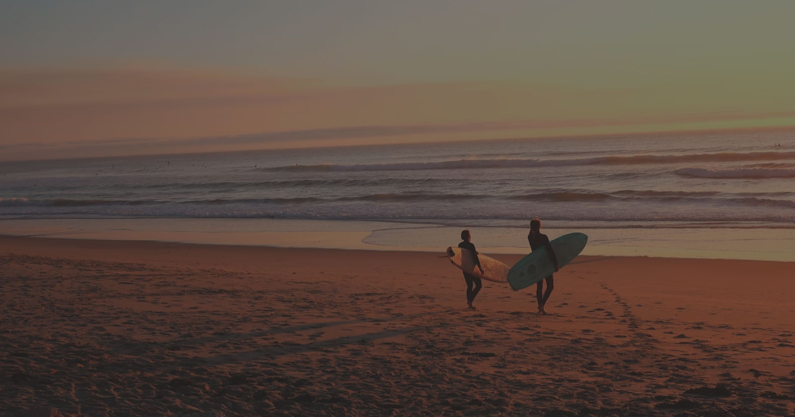 Surfistas con sus tablas en la playa al atardecer, El Sardinero
